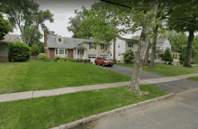 a red car is parked in front of a house in a residential area