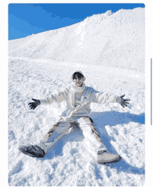 a person is laying in the snow with their arms out