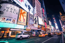 a busy city street with a billboard for a show called war & peace