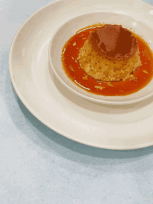 a white plate topped with a pudding with caramel sauce