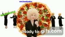 a woman in a suit is standing in front of a large pizza ..