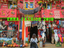 a woman stands in front of a store called enna fashion in 2018