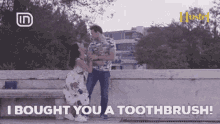 a man and a woman are sitting on a bench and the man is saying i bought you a toothbrush