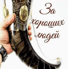 a person is holding a horn in their hand with the words `` za хороших людей '' written on it .