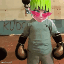 a person wearing boxing gloves is standing in front of a wall that says kudc