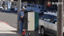 a man standing on a sidewalk next to a box that has a sticker on it that says ' electrical box '