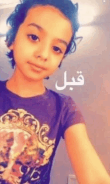 a young boy wearing a purple shirt is taking a selfie with arabic writing on the bottom .