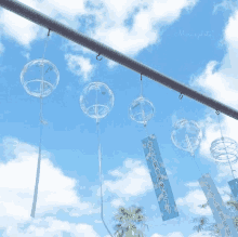 a bunch of wind chimes hanging from a pole with a blue sign that says ' mizu 's photo ' on it