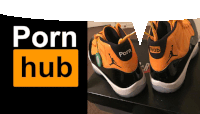 a pair of orange and black basketball shoes with porn hub written on the side