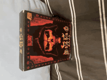 a box of diablo 2 sits on a striped blanket