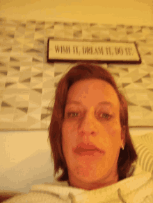 a woman taking a selfie with a sign that says wish it dream it do it