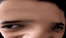 a close up of a person 's face with a blurry background and their eyes looking at the camera .