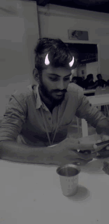 a man with horns on his head is sitting at a table