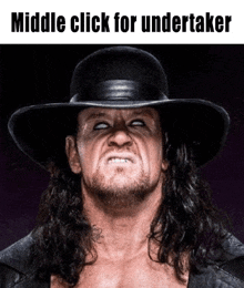 the undertaker is wearing a black hat and making a face .