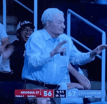 a man in a white shirt stands in front of a scoreboard that says georgia st 56 old dominion 67