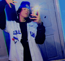 a person wearing a blue jays jersey taking a picture of themselves