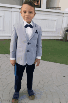 a young boy in a suit and bow tie