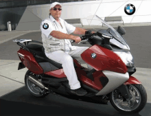 a man sitting on a red bmw motorcycle