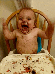 a baby is sitting in a high chair with his mouth open