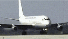 a white airplane is taking off from a runway