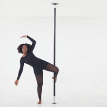 a woman is standing on a pole with one leg up