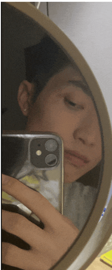 a person taking a selfie with their phone in a mirror