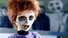 a creepy doll with red hair and blue eyes is wearing a purple shirt .