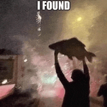 a man is holding a large fish over his head in a crowd .