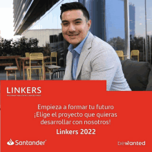 a man in a suit sits in front of a sign that says ' linkers 2022 ' on it