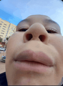 a close up of a person 's nose and mouth with a building in the background