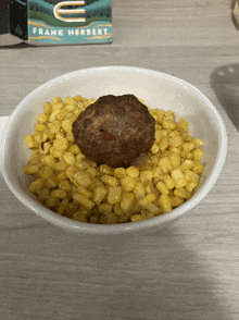 a bowl of corn and a meatball with a frank herbert book behind it