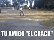 a man is kicking a soccer ball on a field with the words " tu amigo el crack " above him