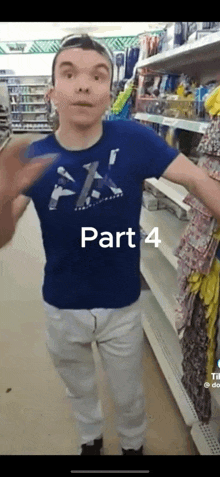 a man in a blue shirt and white pants is standing in a store and talking .