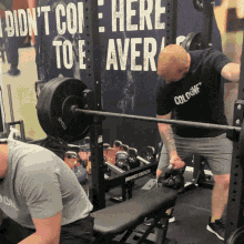 a man lifts a barbell in front of a sign that says i did n't come here to e aver