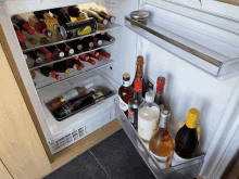 a fridge filled with bottles of alcohol including a bottle that says ' smirnoff ' on it