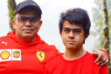 a man wearing a red ups shirt stands next to a boy wearing a red shirt