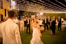 a bride and groom are dancing under a canopy with lights