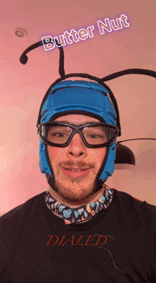 a man wearing glasses and a blue helmet with the words butter nut above his head