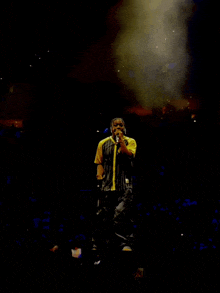 a man singing into a microphone on a stage