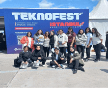 a group of people posing for a picture in front of a sign that says teknofest