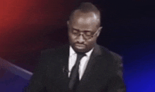 a man in a suit and tie is standing in front of a podium .