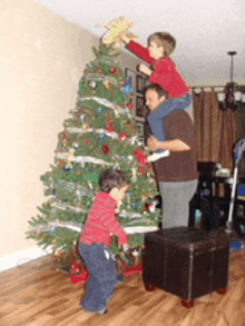 a family decorates a christmas tree together in a living room