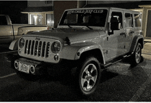 a white jeep with a 6th child jeep club bumper sticker on the windshield