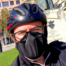 a man wearing a face mask and a helmet stands in front of a statue that says a tatuo