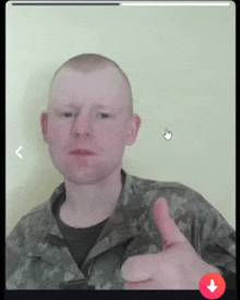 a man in a military uniform is giving a thumbs up sign .