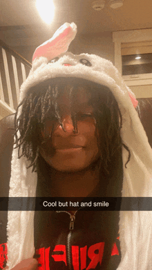 a person wearing a bunny hat and smiling with the words cool but hat and smile below them