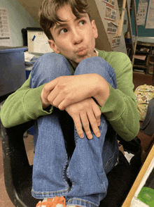 a boy making a funny face while sitting on a chair