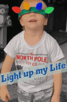 a little boy wearing a north pole toy co shirt