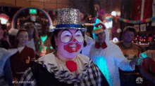 a woman dressed as a clown with a top hat and glasses