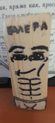 a wooden block with a drawing of a face and the word balepa on it